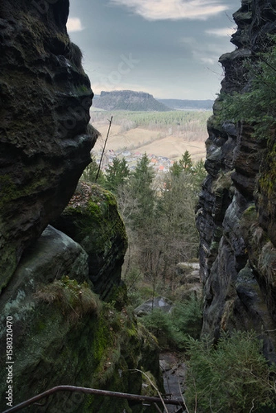 Fototapeta View into a rocky gorge with a wooded valley and hills in the background