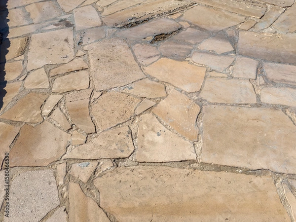 Obraz Close-up of irregular stone pavement surface with natural textured pattern, cracked shapes and grout lines, ideal for background, texture or architectural reference