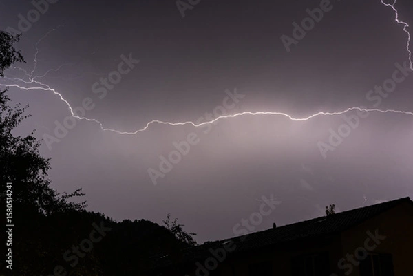 Fototapeta Horizontal Lightning Flash Across a Stormy Night Sky