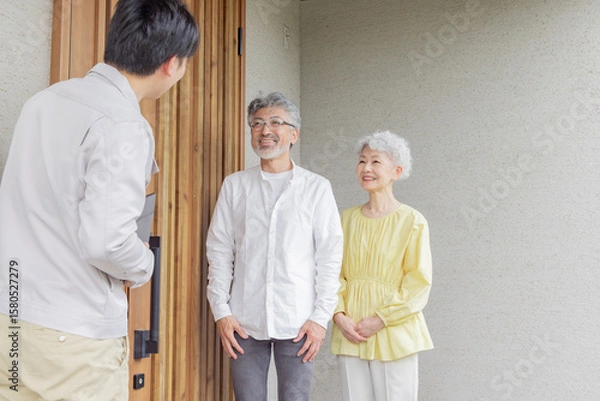 Obraz 住宅の前で説明する男性作業員とシニア夫婦