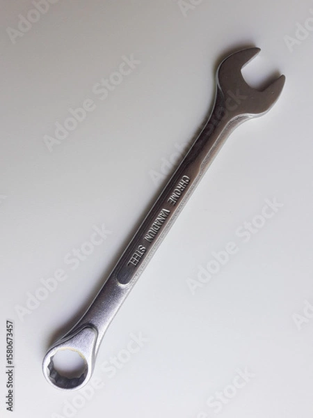 Fototapeta A ring spanner, also known as a combination wrench, isolated on a white background.