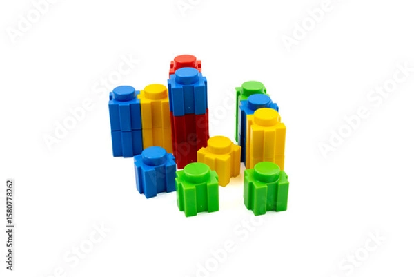Fototapeta Colorful stacked plastic building blocks on white background