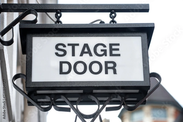 Fototapeta Low angle view of overhead stage door sign on exterior of theatre building.