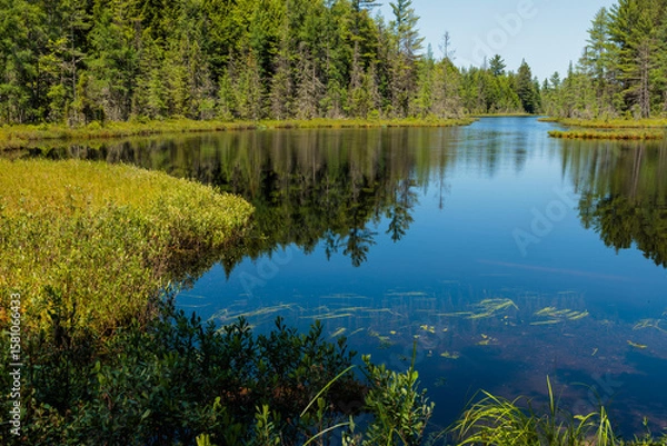 Fototapeta Calm water of Devils Lake near Boulder Juction, Wisconsin in early July