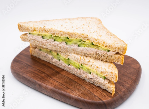 Fototapeta Healthy Tuna Salad and Cucumber Whole Wheat Sandwich on wooden board side view of Perfect for Lunch on white background