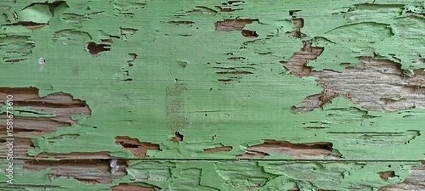 Fototapeta Weathered Green Painted Wood with Peeling and Cracks. Close-up of old wooden surface with peeling green paint, cracks, and decay. Ideal for grunge or rustic texture backgrounds