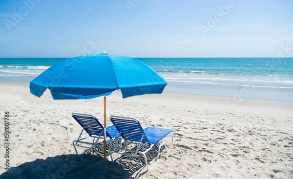 Obraz Beach umbrella and beach chairs sitting on a beautiful, idyllic secluded beach