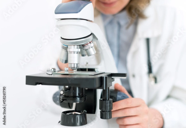 Obraz Scientist using microscope in laboratory.