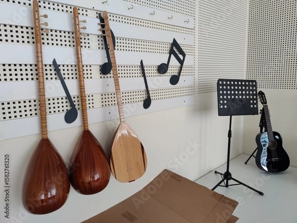 Fototapeta A harmonious blend of tradition and modernity, these stringed instruments—two ouds and a guitar—hang with musical notes, symbolizing a journey of cultural harmony and creative unity.