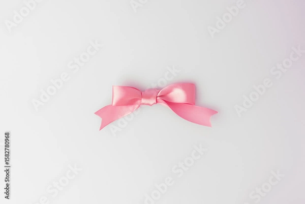Obraz Elegant pink bow on white background. Minimalist composition ideal for gift wrapping, celebrations, greeting cards, and festive designs.