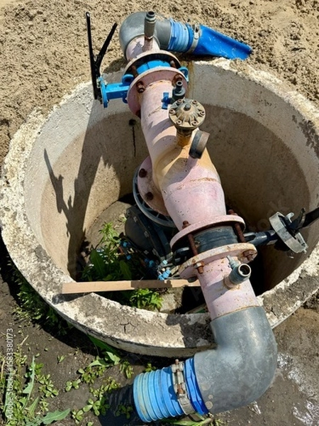Obraz Close up of industrial water pump system with pipes and valves, installed in a protective concrete housing, ensuring efficient water supply and resource management