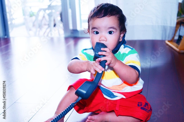 Obraz 受話器で遊ぶ赤ちゃん