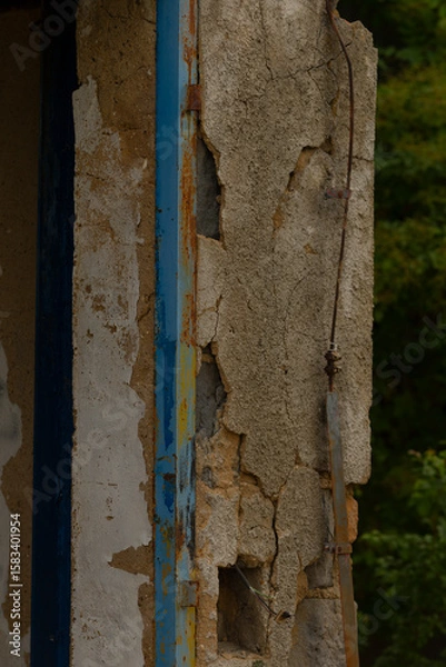 Fototapeta A very old building that features peeling paint throughout and has a charming blue trim along its edges, adding character to its appearance