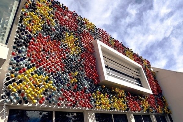 Fototapeta Black, Red and Yellow spheres on the building facade