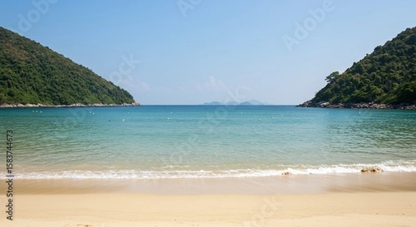 Obraz Scenic Beach with Calm Clear Water and Green Hills Under Bright Blue Sky