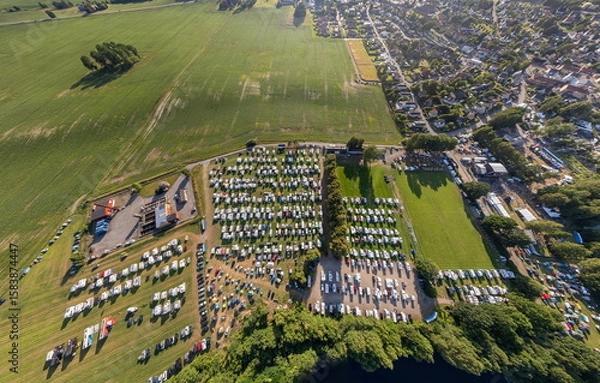 Fototapeta Large countryside campsite with many RVs near a field, panoramic aerial view from drone