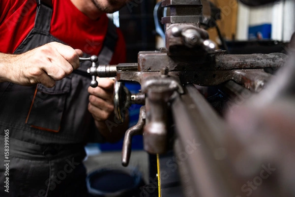 Obraz Metal worker processing steel material on lathe machine.