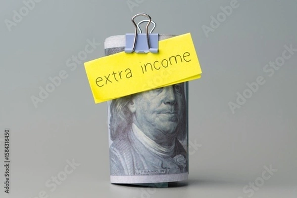 Obraz A hundred dollar bill with a note "extra income". Finance concept.