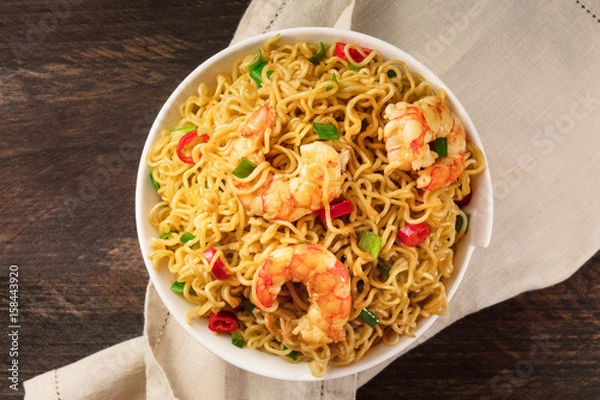 Fototapeta Instant noodles with vegetables, shrimps, and copy space