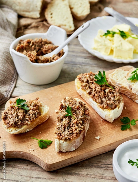Fototapeta Fresh homemade Chicken liver pate with bread on a wooden board over rustic background
