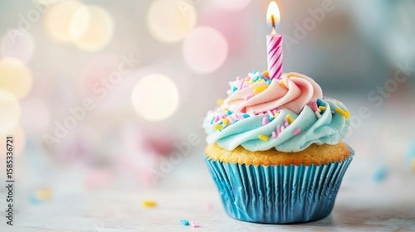 Fototapeta Colorful birthday cupcake with frosting and sprinkles placed on a wooden table against a soft blurred background with festive light tones




