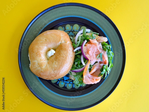 Obraz A salmon bagel with rocket and Spanish onion. 