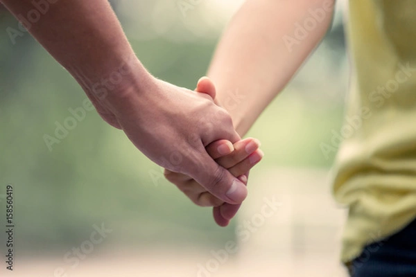 Fototapeta Młoda miłość para trzymając się za ręce i chodzić razem w odcieniu vintage