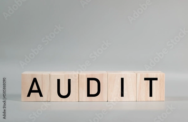 Fototapeta Wooden blocks spelling out the word AUDIT. This image represents the successful completion of a thorough audit, providing a strong foundation for business growth and investor confidence