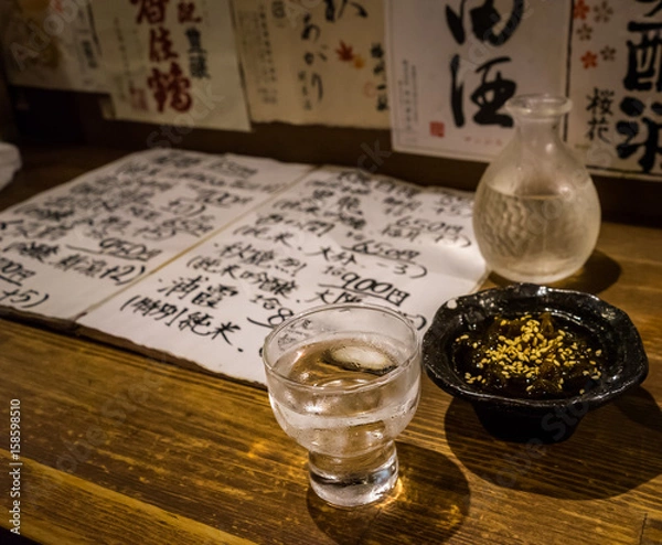 Obraz Traditional japanese sake and seaweed. Japanese menu and sake brands in the background.