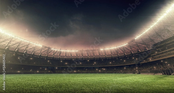 Obraz stadion piłkarski z zieloną trawą, oświetleniem i dramatycznym nocnym niebem