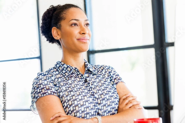 Obraz Portrait of smiling afro-american office worker sitting in offfice