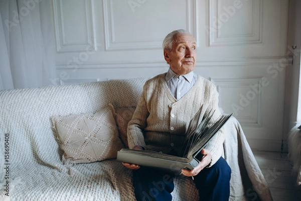 Fototapeta Senior man with photo missing his wife