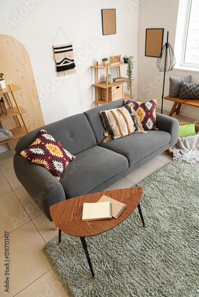 Fototapeta Interior of living room with black sofa, coffee table and cushions