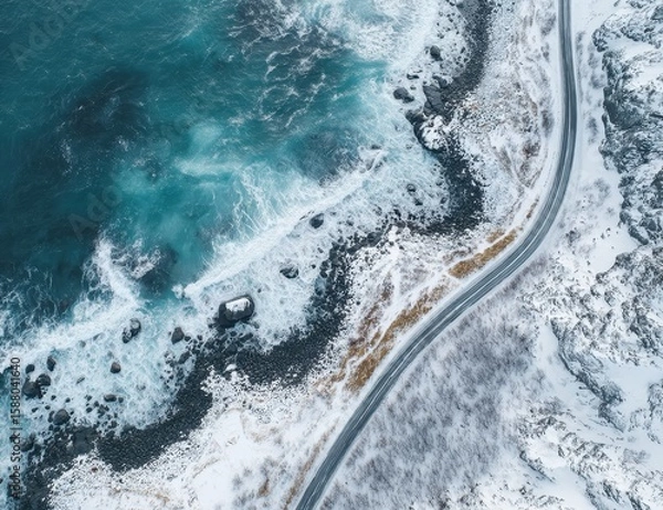 Fototapeta High-angle view of a winding road bordering a wintry coastline