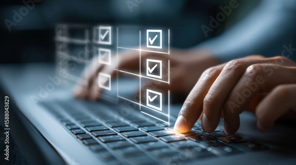Fototapeta A person is completing a digital checklist on a laptop, hove their fingers over the keyboard to select options in the virtual form on the screen displayed.
