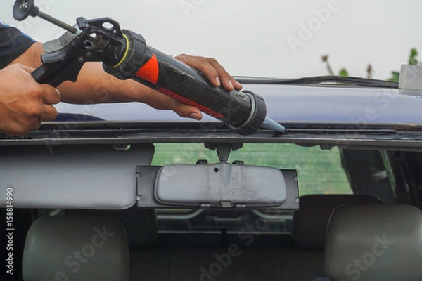 Fototapeta Glazier using tools repairing to fix crack broken windshield, windscreen on the front window glass of the machine car accident.