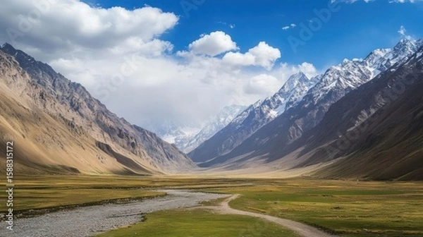 Fototapeta Majestic mountain range unfolds beneath a blue sky, a winding river traversing a vast green valley, where nature's splendor and tranquility intertwine seamlessly