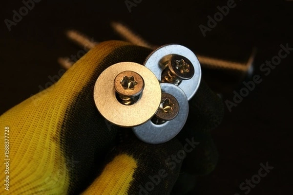 Obraz Construction work process. Construction worker holding large bolts with washers