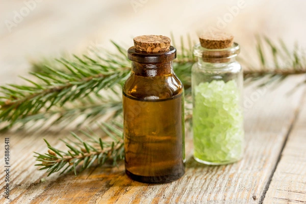 Fototapeta cosmetic spruce oil and salt in bottles with fur branches on wooden table background