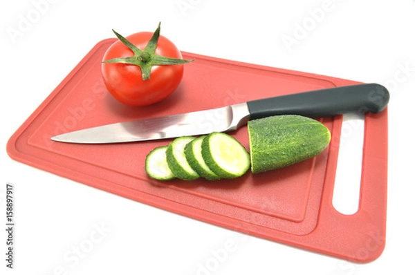 Obraz Огурец помидор и нож на разделочной доске 