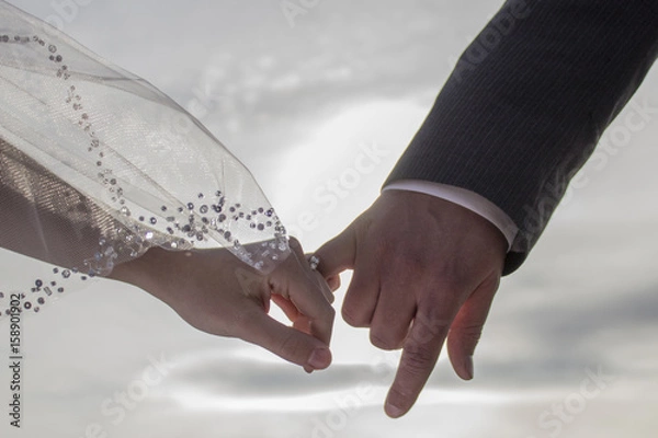 Obraz Bride and groom linking pinkies