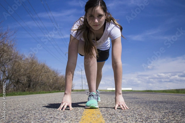 Obraz Female getting ready to begin running