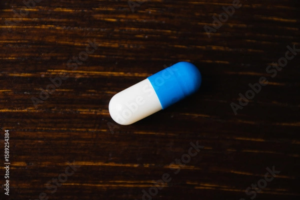 Fototapeta Pill, vitamin on wooden table, dark background with space for text. Self-medication concept.
