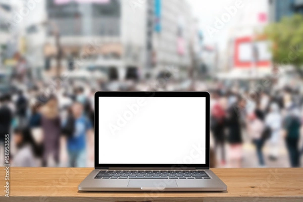 Fototapeta Laptop with blank screen on table with shibuya blurred background
