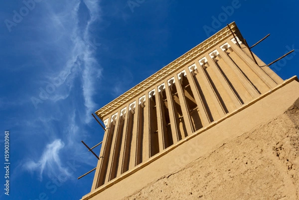 Fototapeta Close-up of a traditional windcatcher (badgir) against a vibrant blue sky in Yazd, Iran—an iconic element of Persian desert architecture.


