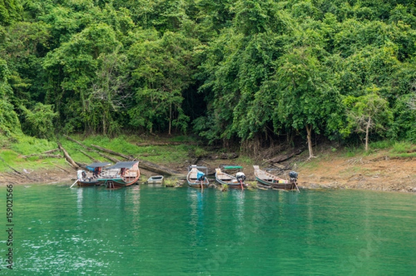 Fototapeta Longtail boats floating on the emerald green waters of Cheow Lan Lake