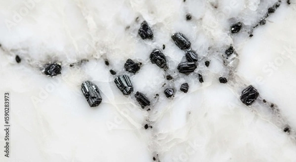 Fototapeta Close-up view of a polished white marble surface with dark mineral inclusions.