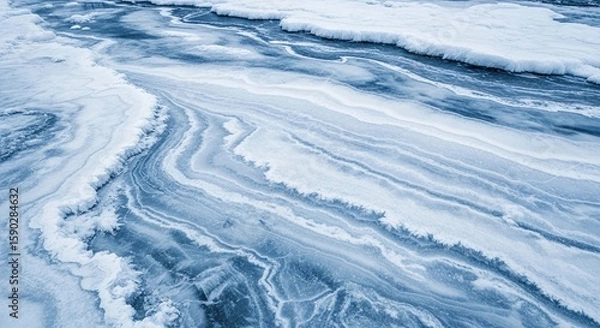 Fototapeta Abstract aerial view of a frozen river or lake showing intricate patterns of ice, snow, and water.