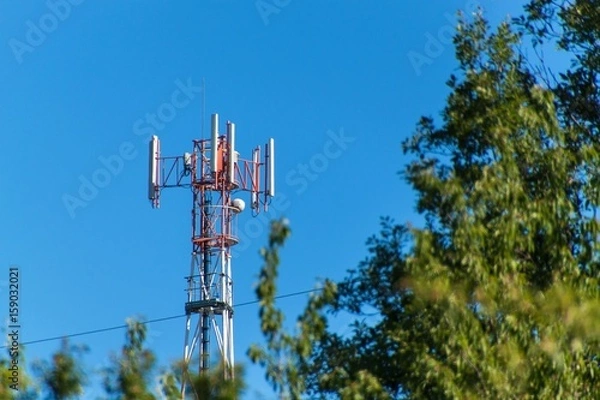 Fototapeta Technology on the top of the telecommunication GSM. Masts for mobile phone signal. Tower with antennas of cellular communication on the background of blue sky.