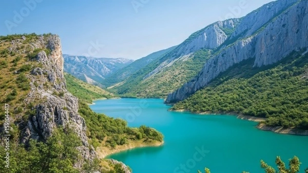 Fototapeta Scenic view of a lake with turquoise water surrounded by mountains